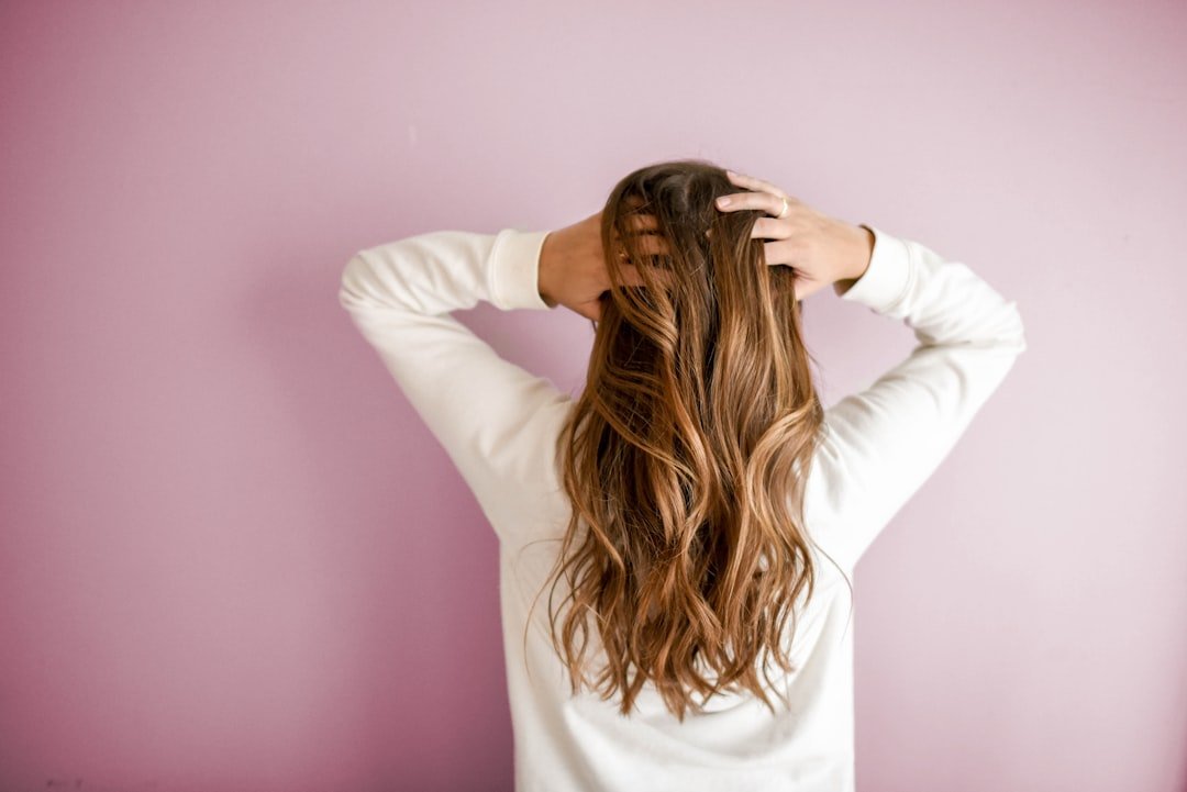 about-img woman-in-white-long-sleeved-shirt-standing-in-front-of-pink-wall-wcpg9rozbm0